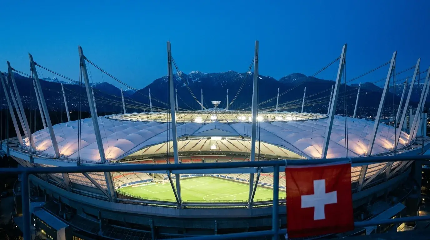 Das BC Place Stadion in Vancouver bei Nacht mit erleuchteter Fassade und Bergsilhouette im Hintergrund.